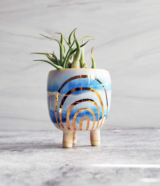 Small planter with cream and blue glaze and painted on gold rainbow