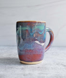 Ceramic mug with handle in purple glaze with green at the top.