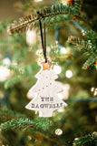 Christmas Tree shaped ornament in white, with name stamped in black. Gold dot ornaments painted on. 