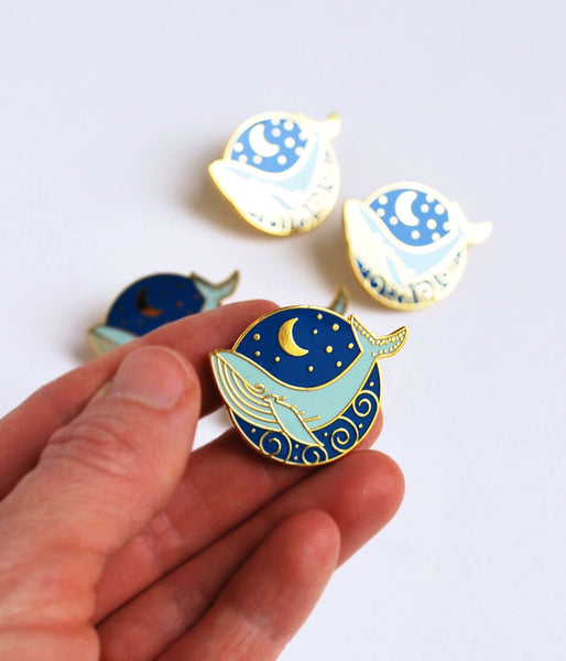Blue Whale and Moon Enamel PinBlue Whale and Moon hard enamel cloisonné pin. This high-polished pin has a royal blue background, light blue whale, and gold accents. Add some beautiful bling to yo