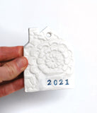 house shaped ornament, in white, with lace imprint, handstamped with year in black ink