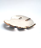 A view from the side of a white leaf bowl with gold edge